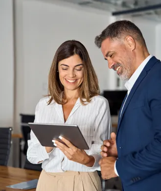 man and woman in business attire looking at an ipad used on a page for adelaide insurance brokers
