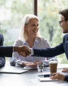 a couple with a man in a business suit meetings and shaking hands over a coffee used on a Cairns insurance brokers landing page