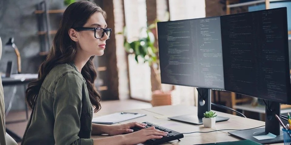 woman looking at screens used in a blog about steps to take in a cyber attack response plan