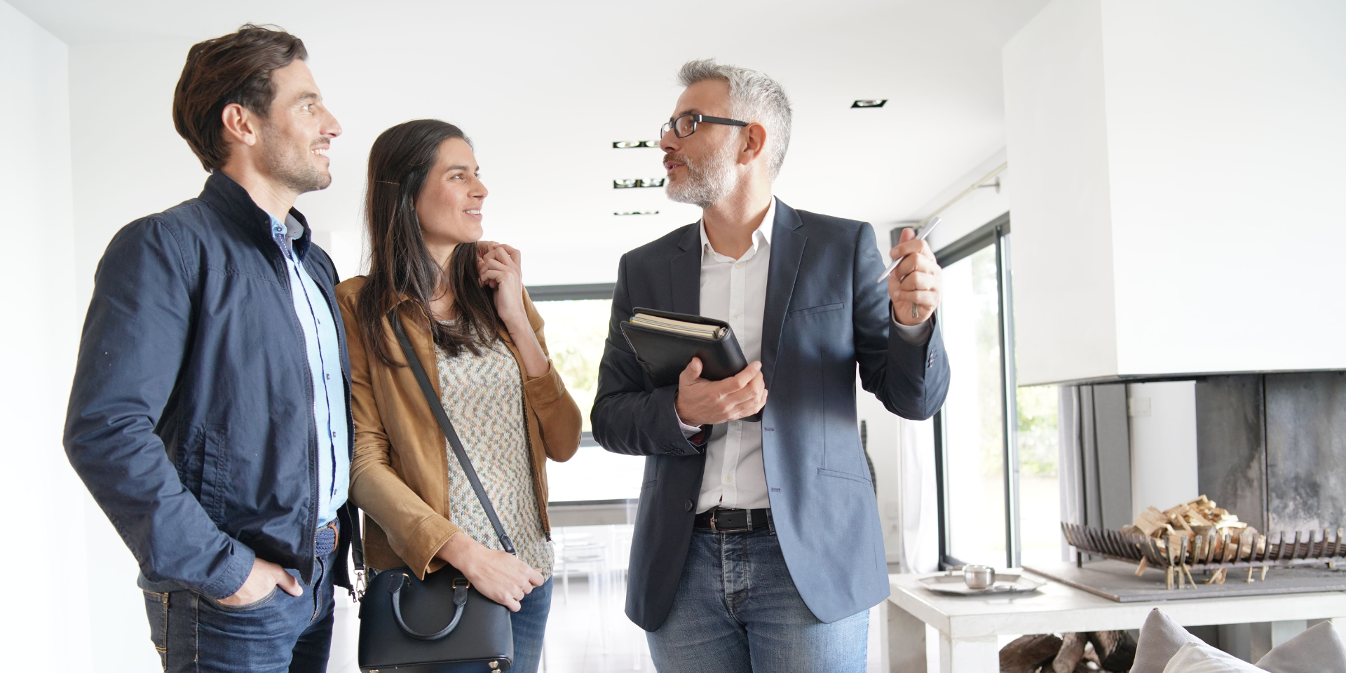 Real Estate Agent showing a couple around a house used on a blog about real estate insurance